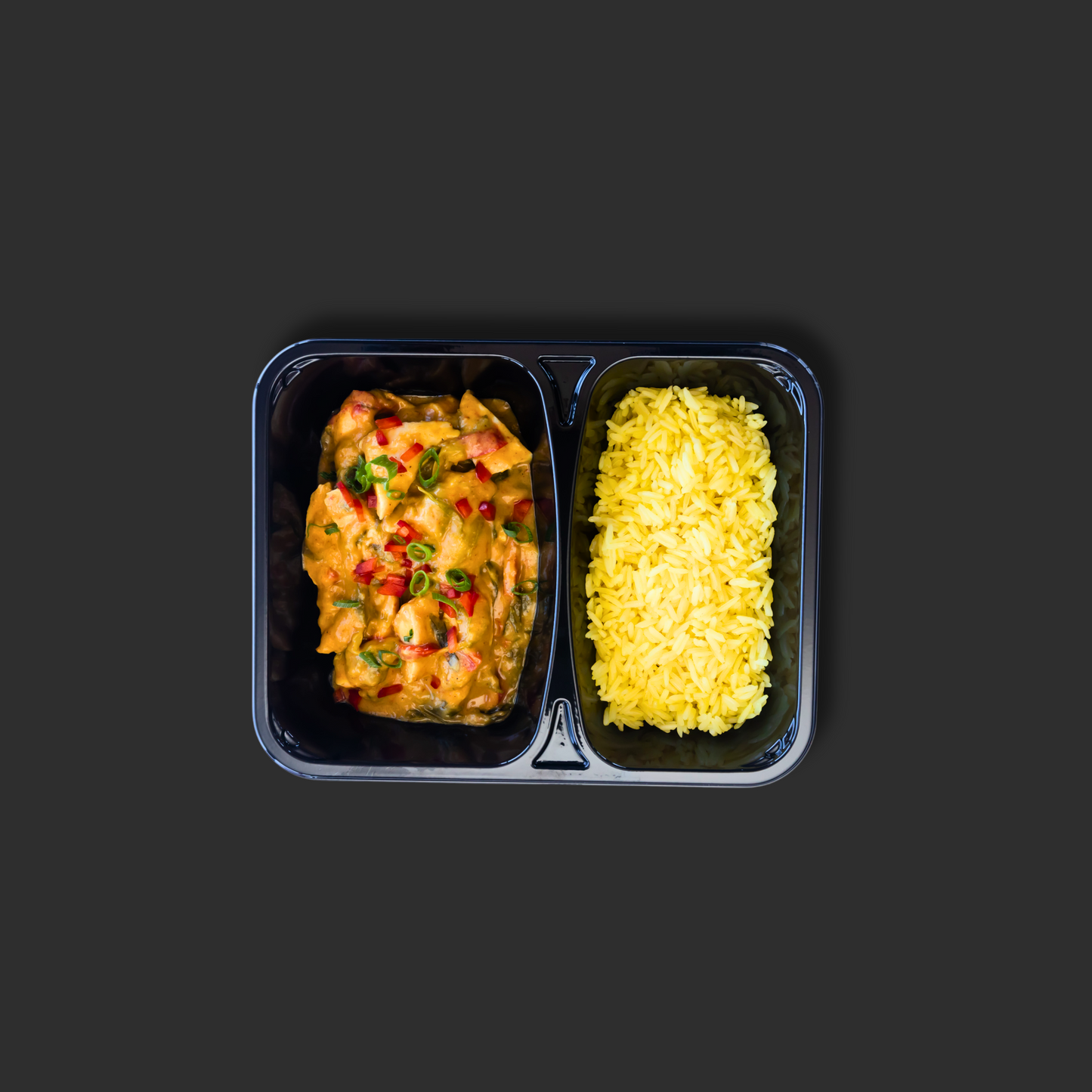 Thai yellow chicken curry served in a black ready meal container with compartment 1 containing chicken in curry sauce and compartment 2 containing saffron infused steamed rice
