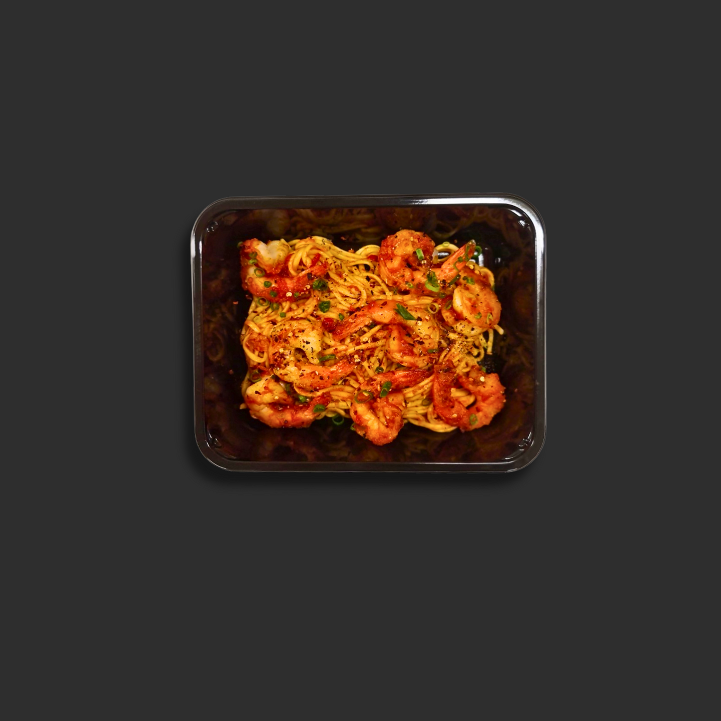 Linguine Prawn Arrabbiata served in a black ready meal container with prawns, pasta, spicy tomato sauce and chili garnish
