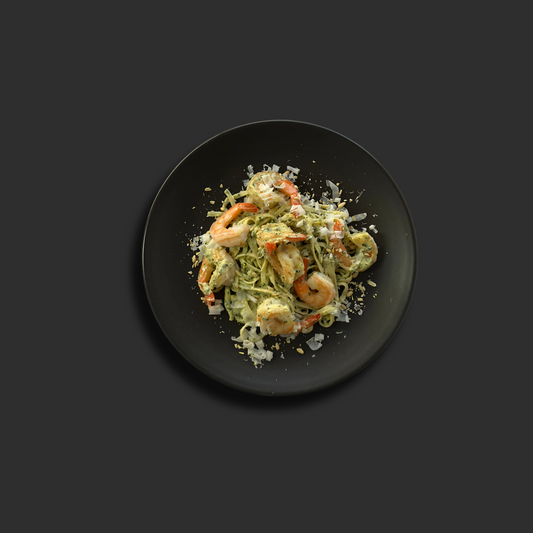 Fresh linguine with succulent prawns in creamy basil pesto sauce in a bowl