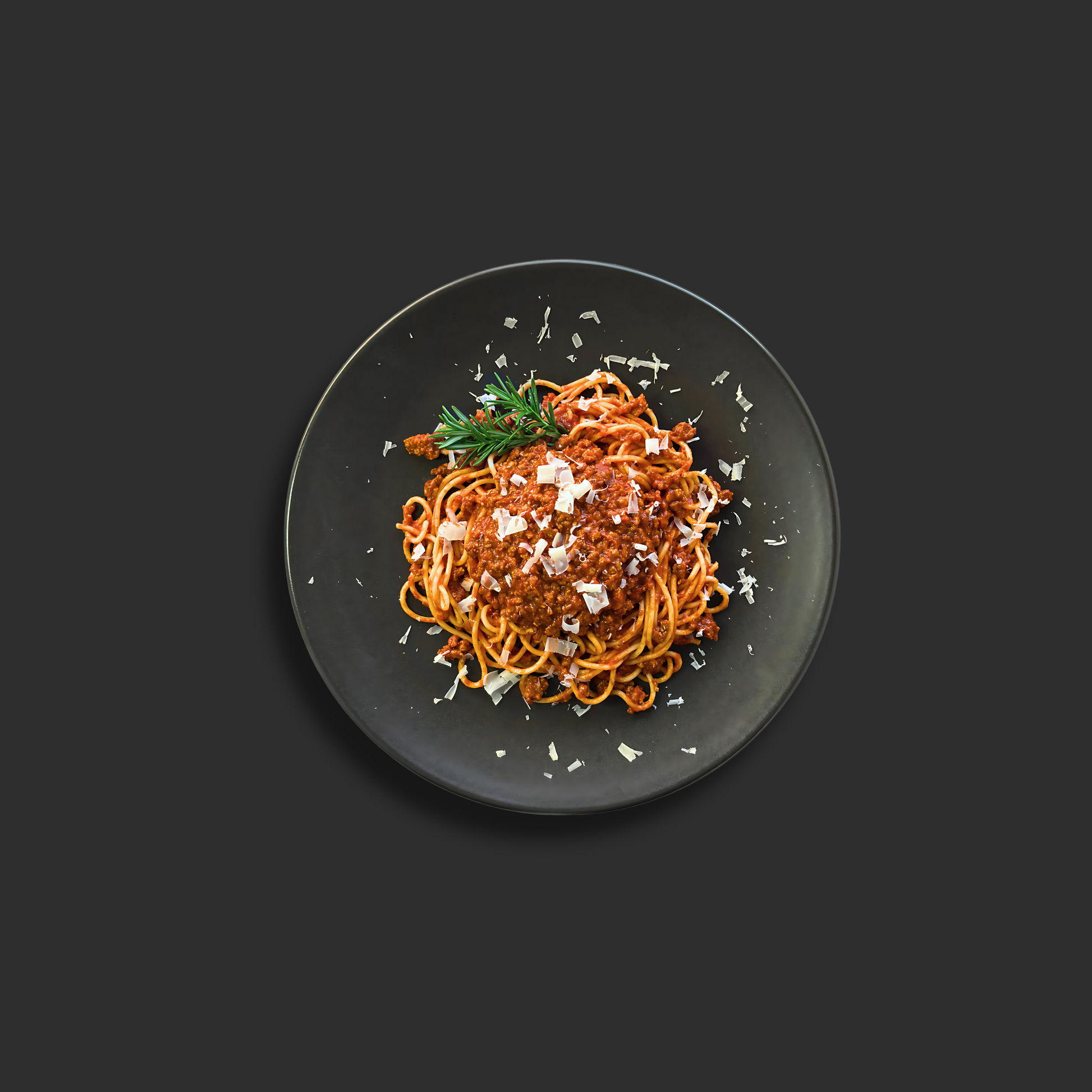 Spaghetti Bolognese with rich meat sauce, featuring al dente spaghetti pasta topped with traditional Italian beef and tomato Bolognese sauce and grated parmesan cheese on a black plate.

